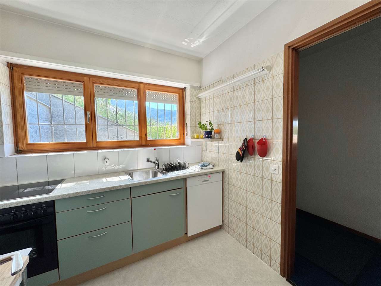 Küche mit Fensterfront und Fliesenwand