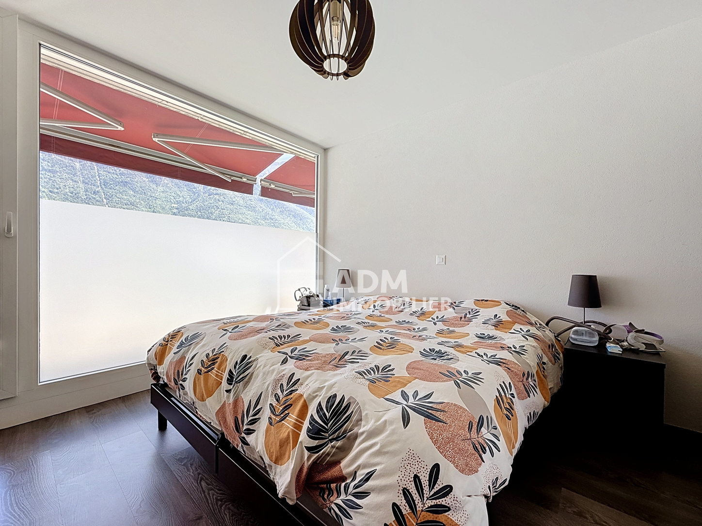 Helles Schlafzimmer mit großem Fenster und Bergblick
