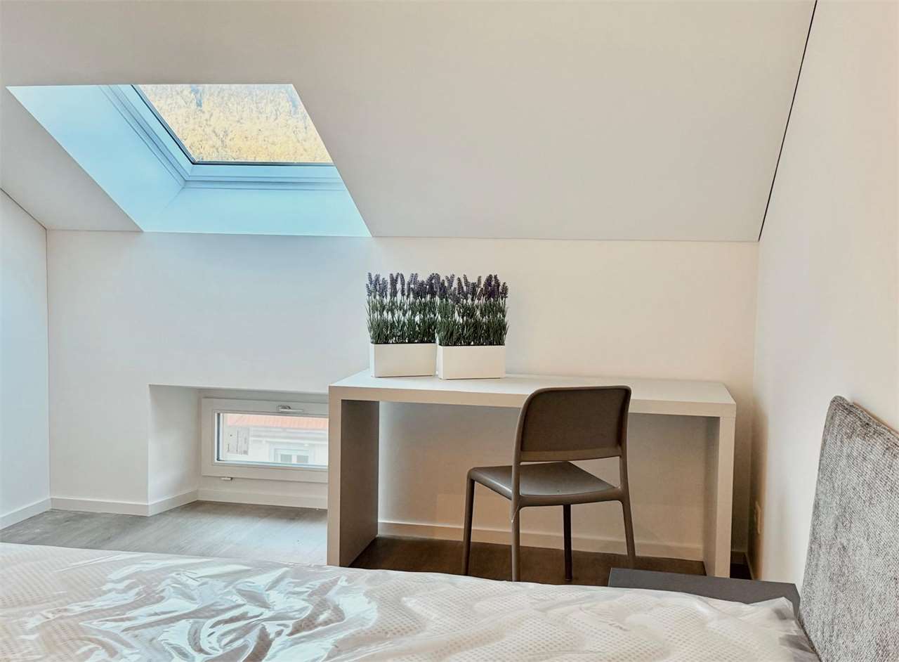 Dachzimmer mit Bett und Schreibtisch