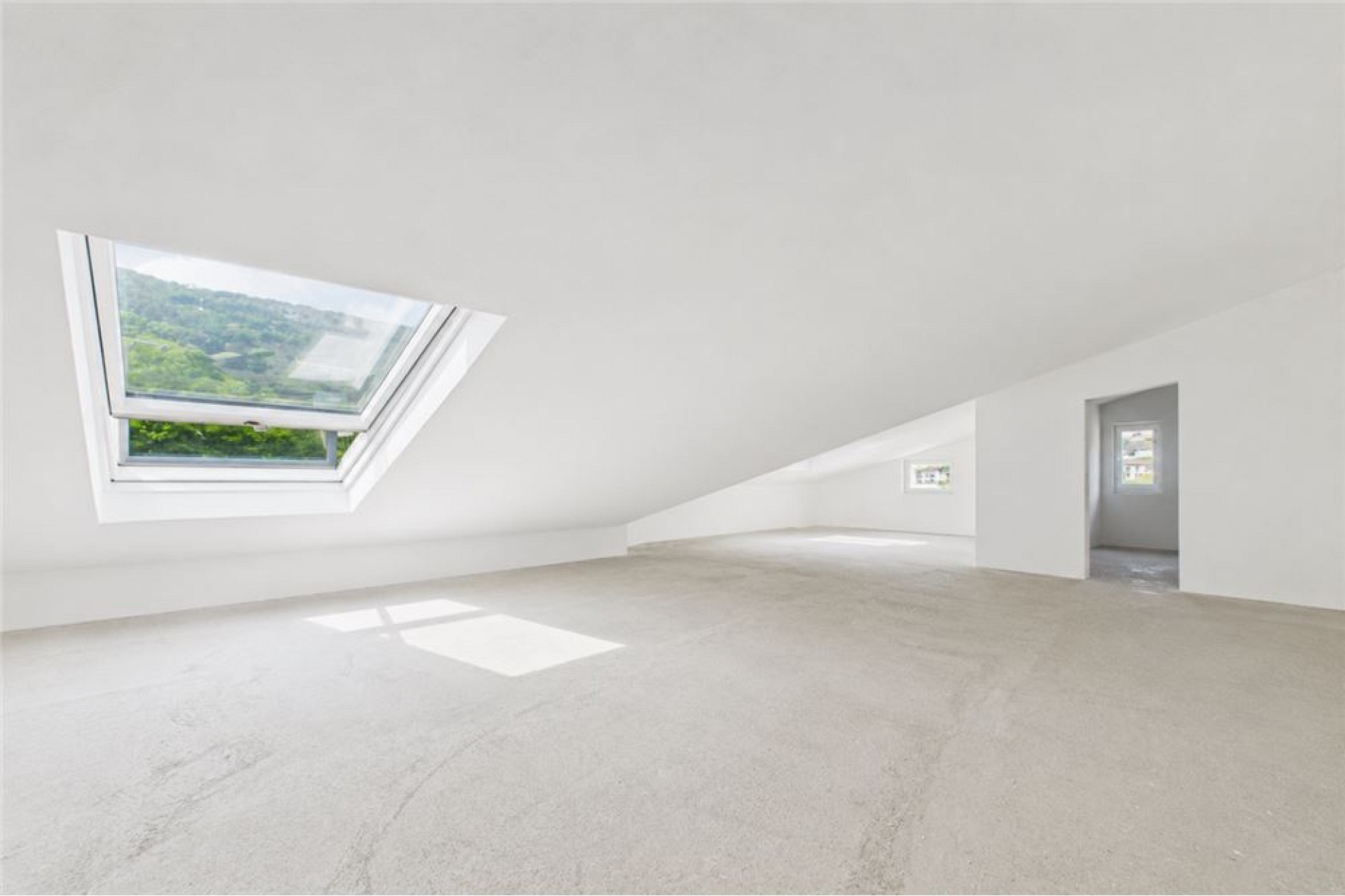 Ausgebauter Dachraum mit Dachfenster und Blick ins Grüne