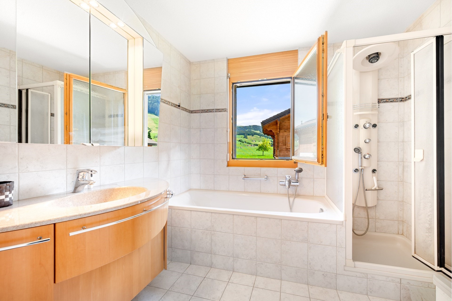 Helles Badezimmer mit Badewanne und Blick ins Grüne