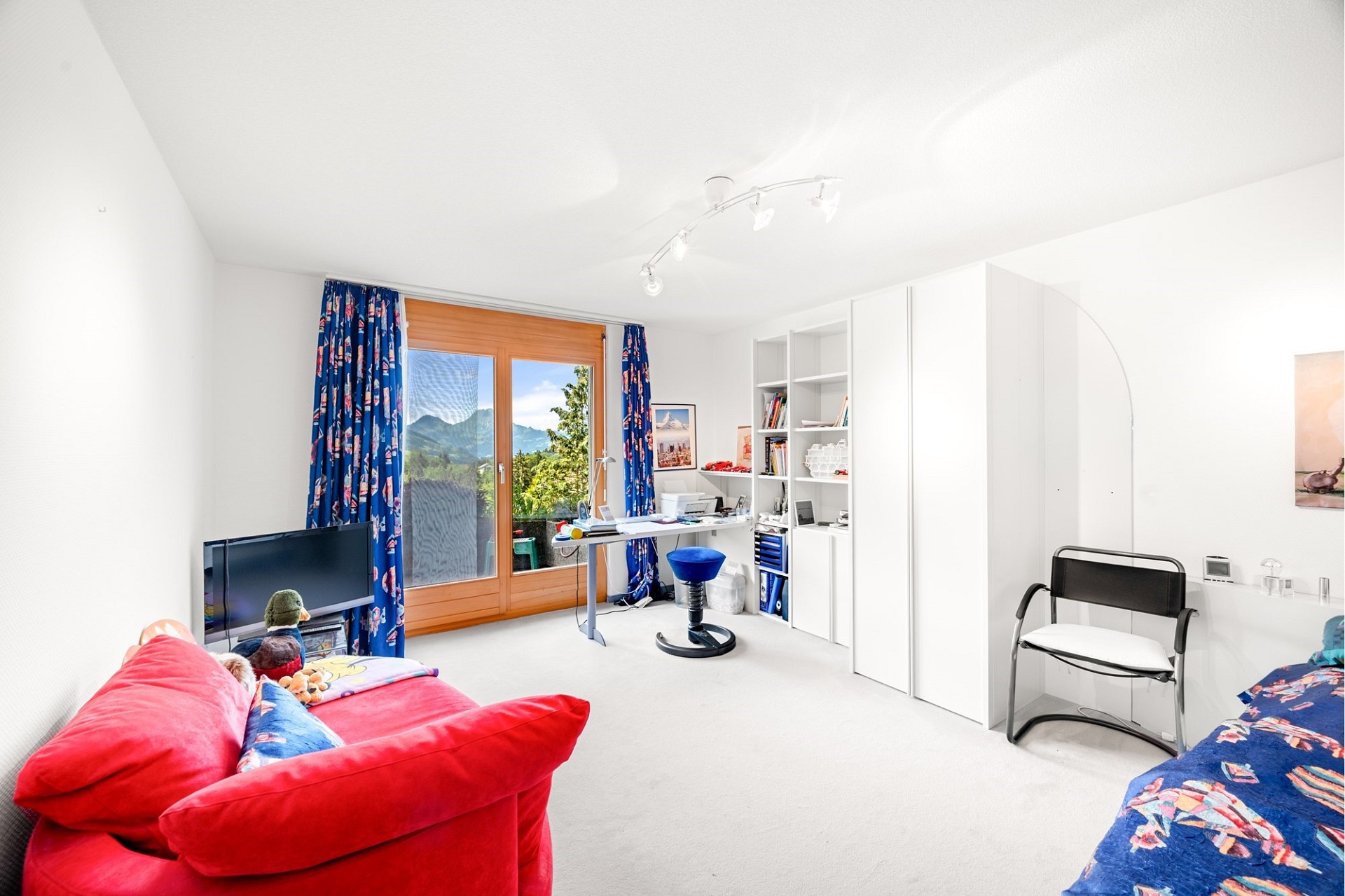 Helles Schlafzimmer mit Balkonblick und Arbeitsbereich