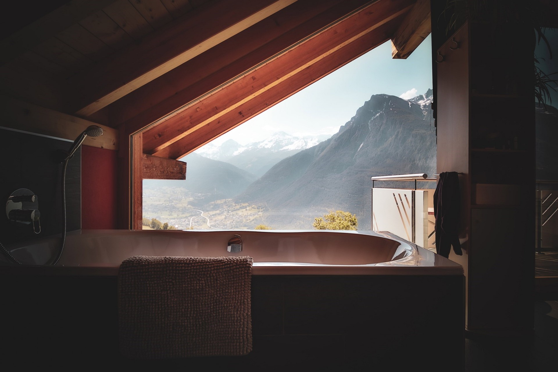 Badezimmer mit Panoramafenster und Bergblick