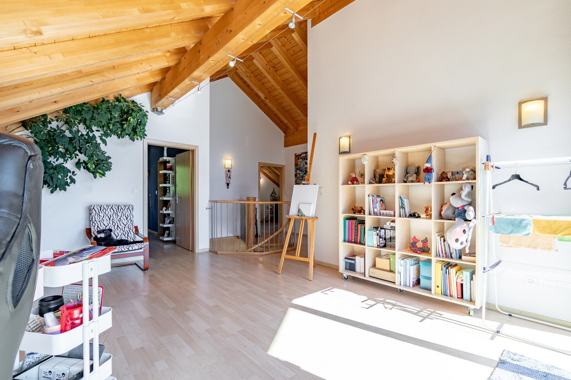 Heller Dachraum mit Holzdecke und Spiel-/Arbeitsbereich