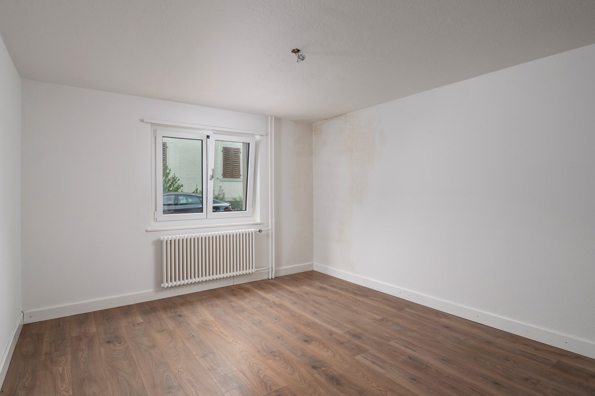 Leeres Zimmer mit Fenster und Heizkörper
