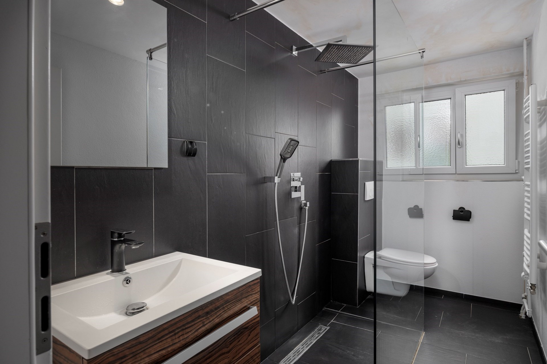 Modernes Bad mit dunkler Dusche