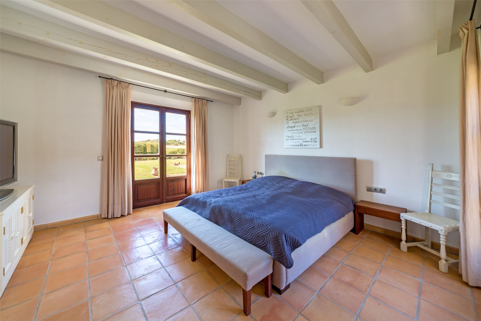Helles Schlafzimmer mit Terrassentür und Blick ins Grüne