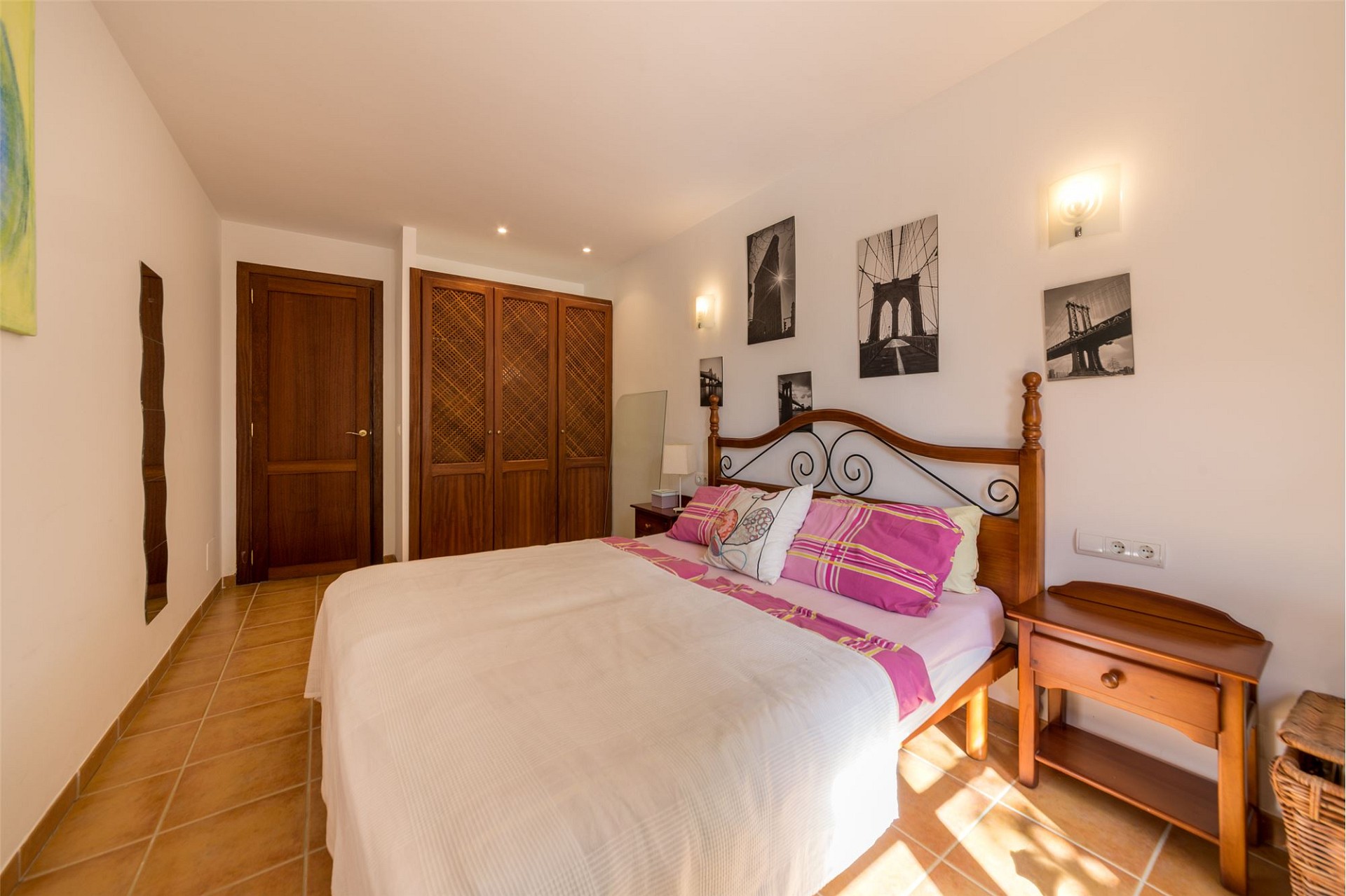 Schlafzimmer mit Holzmöbeln und warmem Fliesenboden