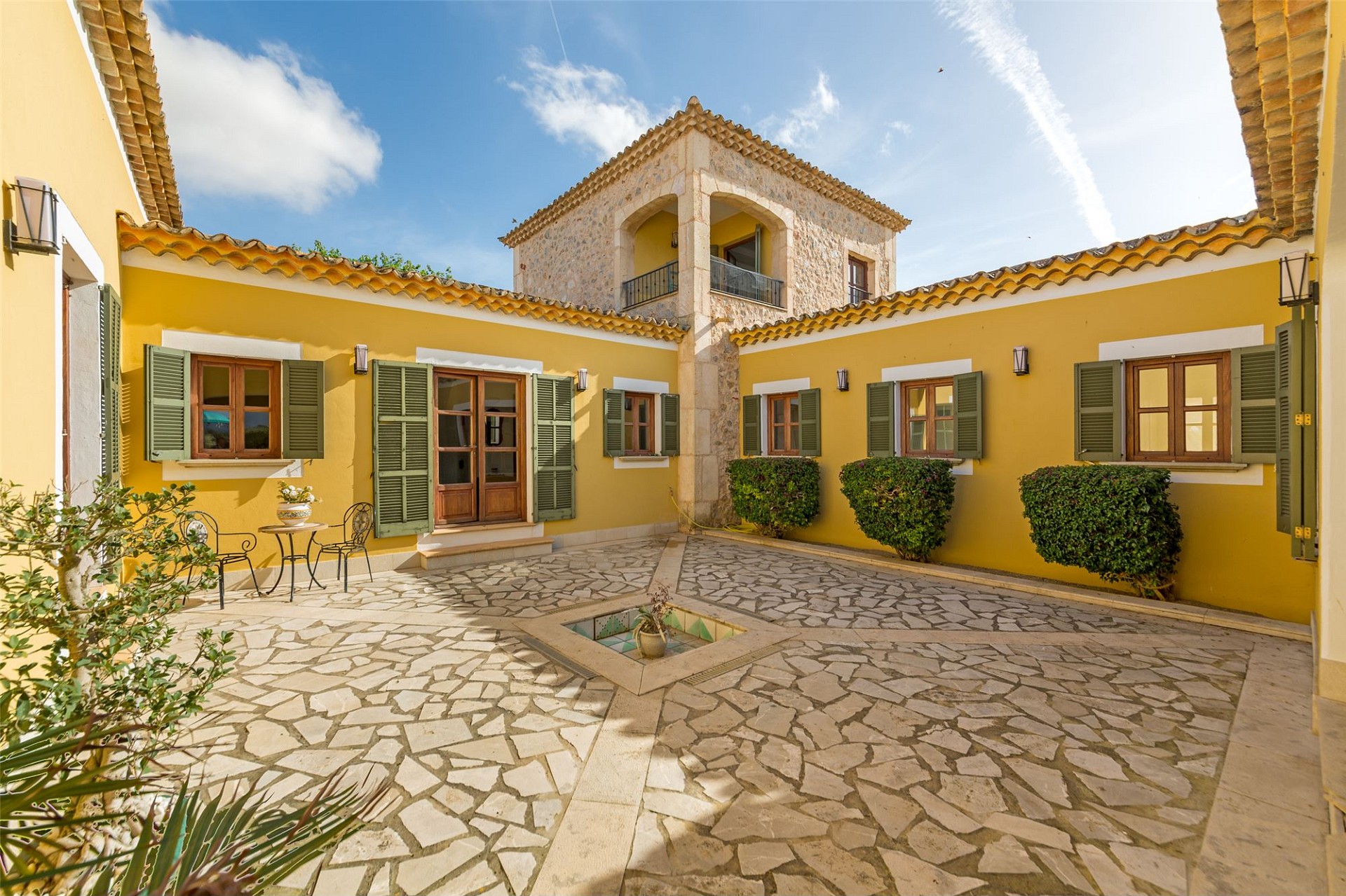 Mediterraner Innenhof mit gelber Fassade