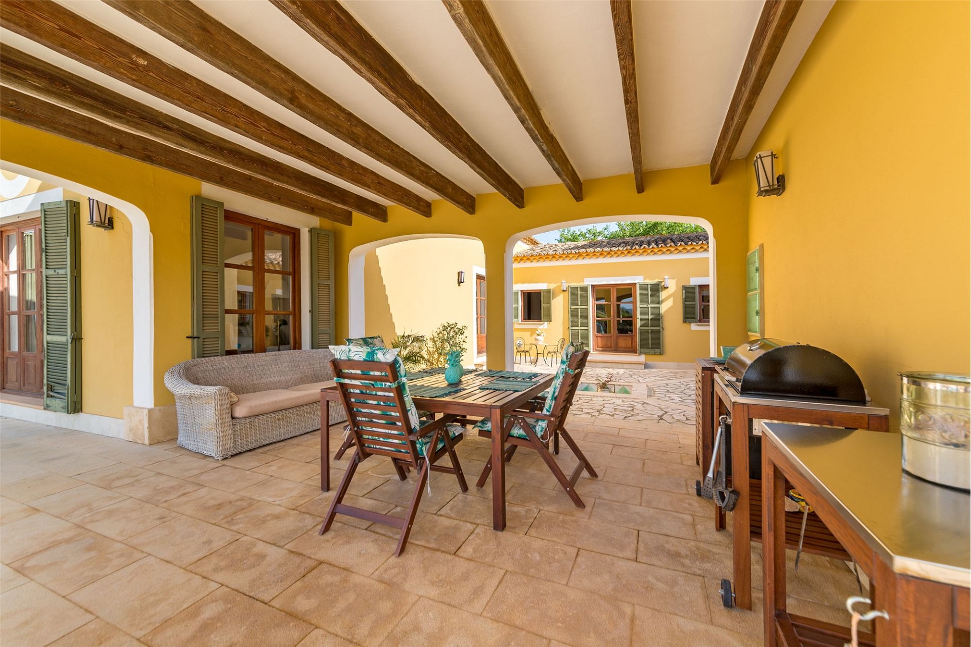 Überdachte Patio-Terrasse mit Ess- und Sitzbereich