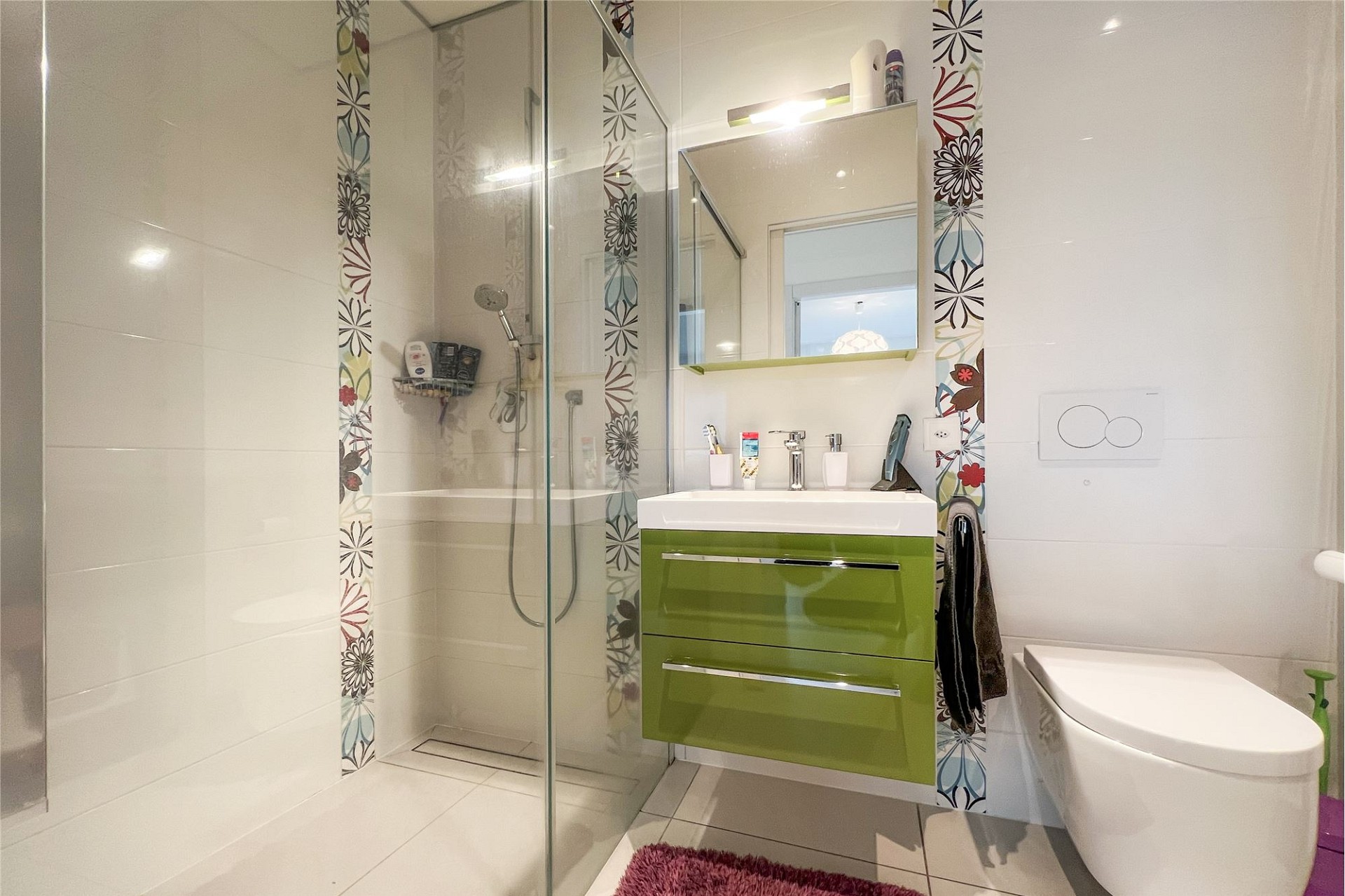 Modernes Badezimmer mit Duschbereich und grünem Waschtisch