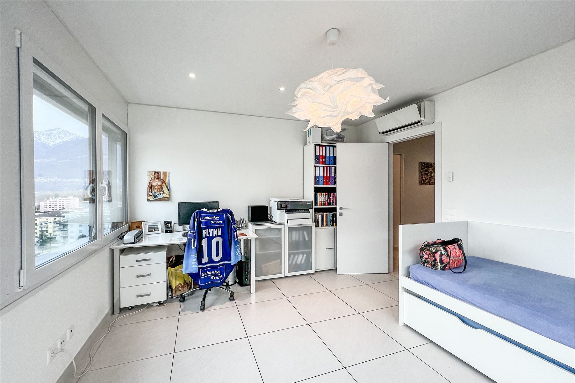 Helles Schlafzimmer mit Arbeitsplatz und Bergblick