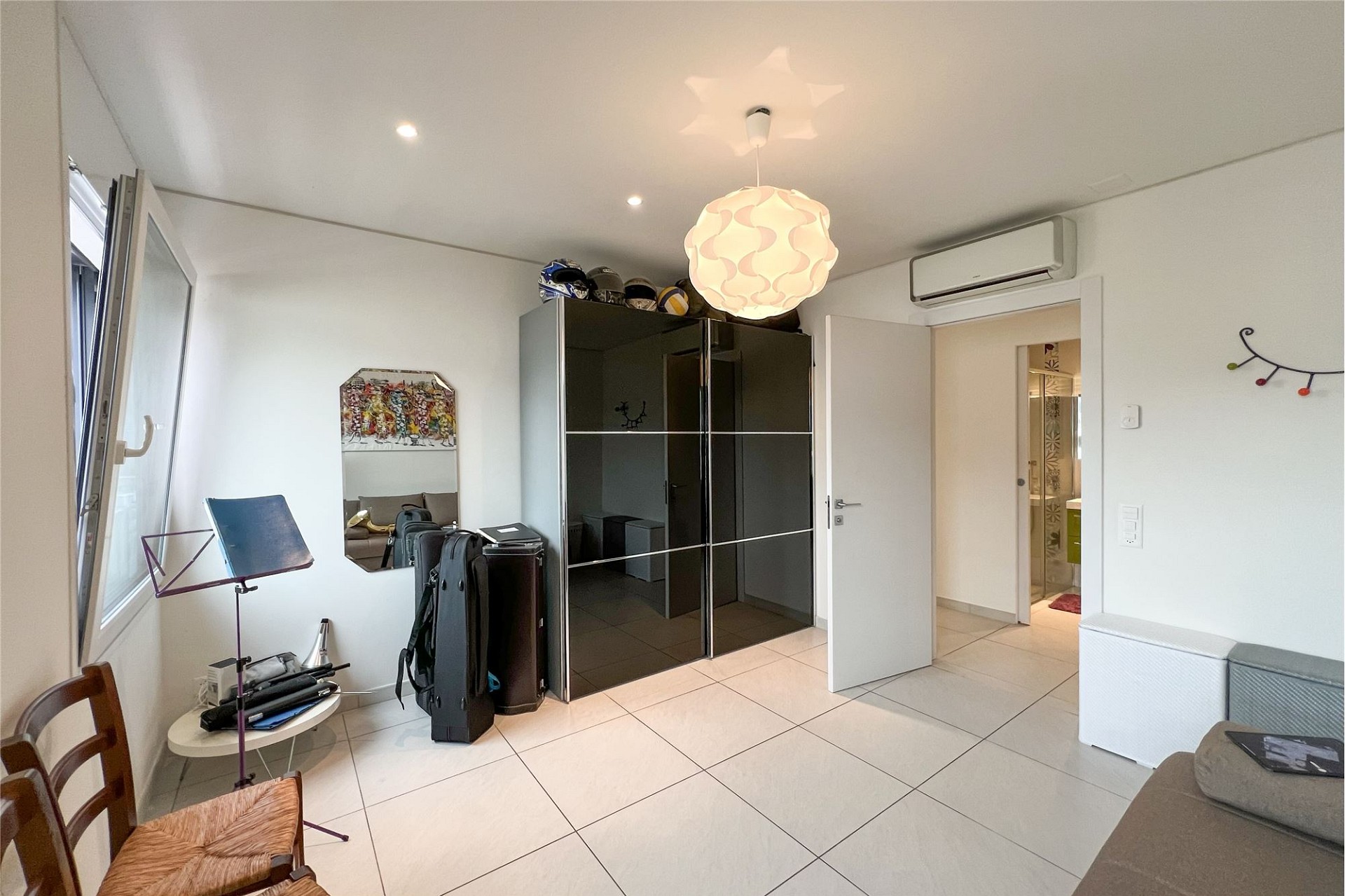 Modernes Schlafzimmer mit Schrankwand und Badezimmerblick
