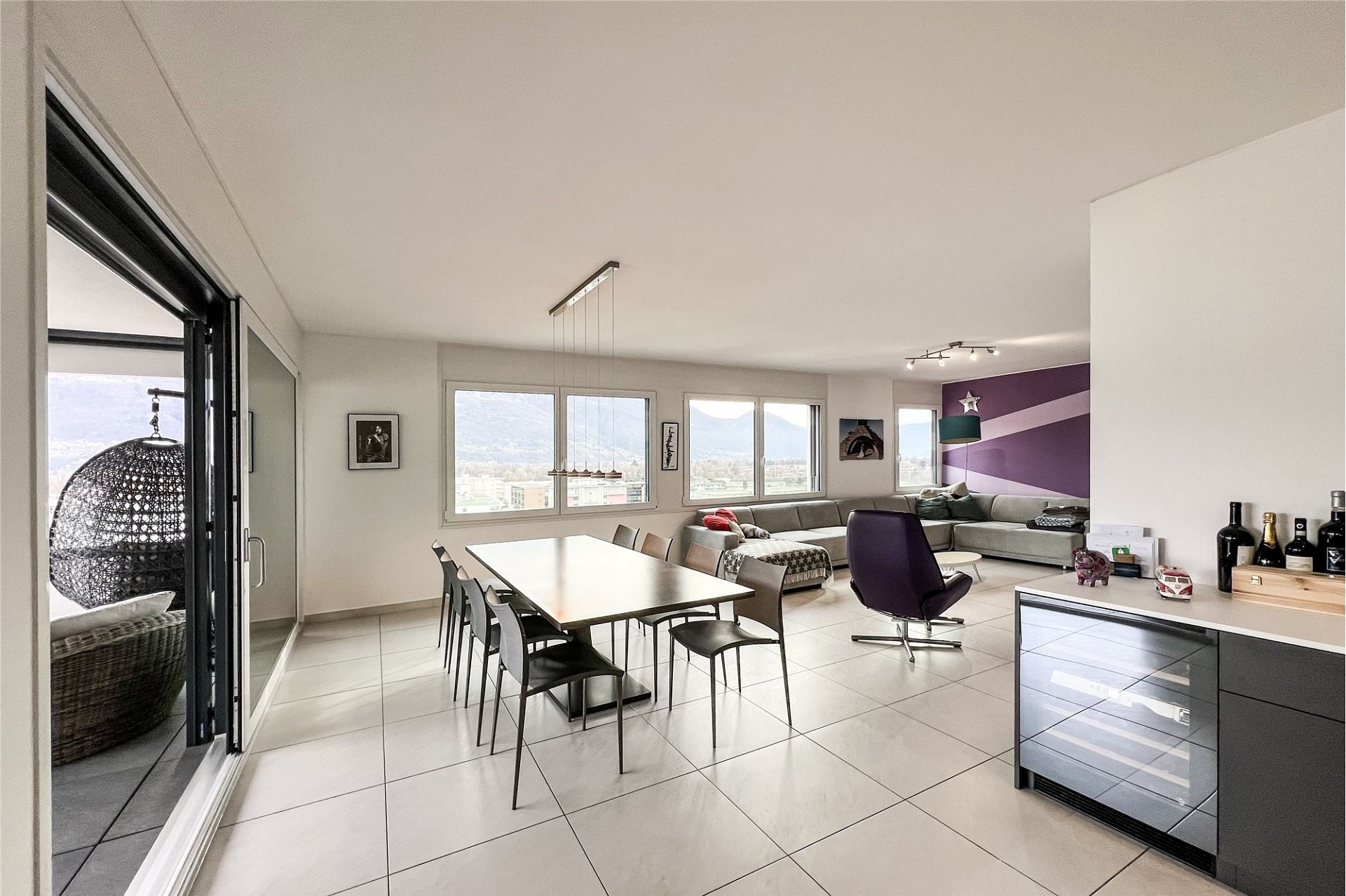 Offener Wohn-Essbereich mit Balkon und Bergblick