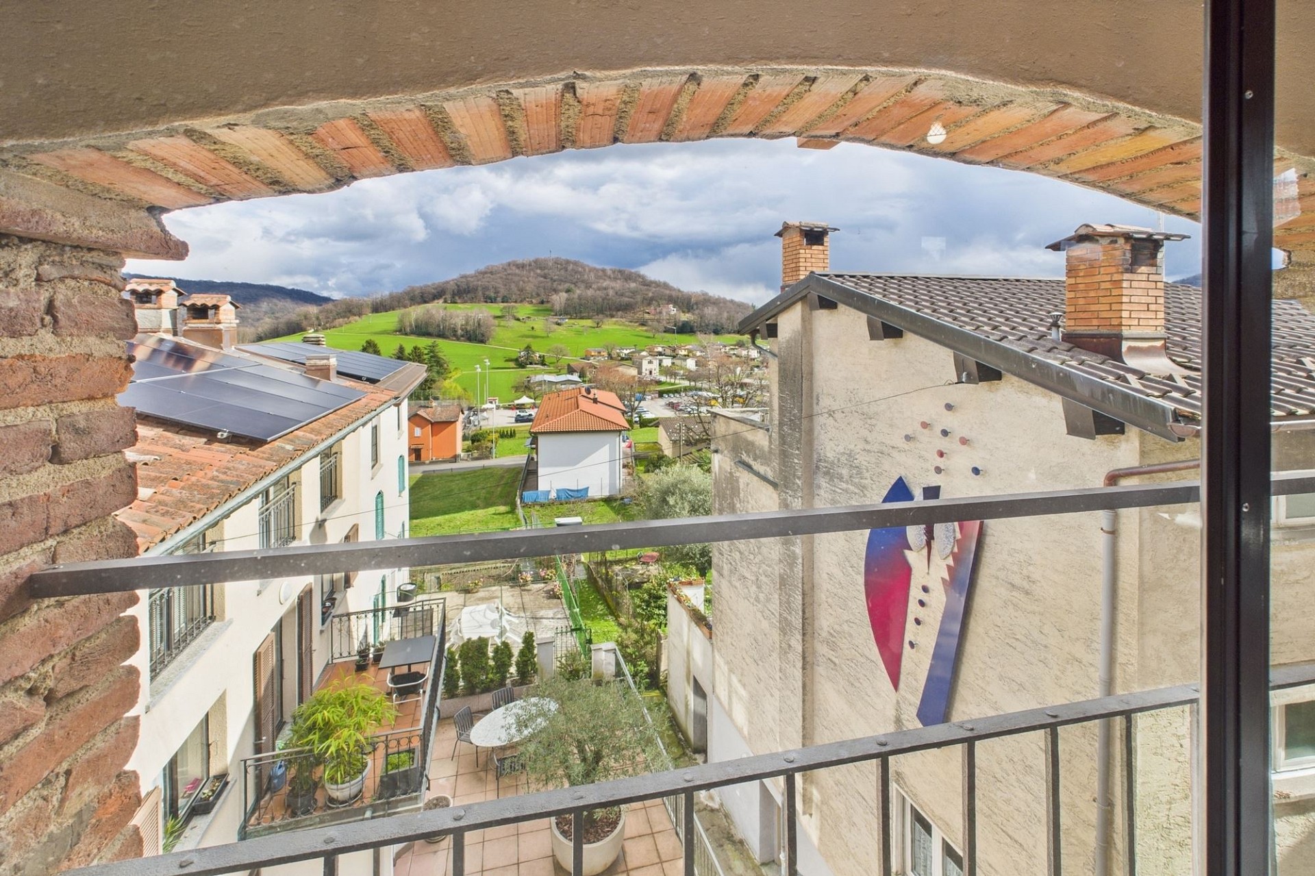 Blick vom Balkon auf Wohngebäude und Hügellandschaft