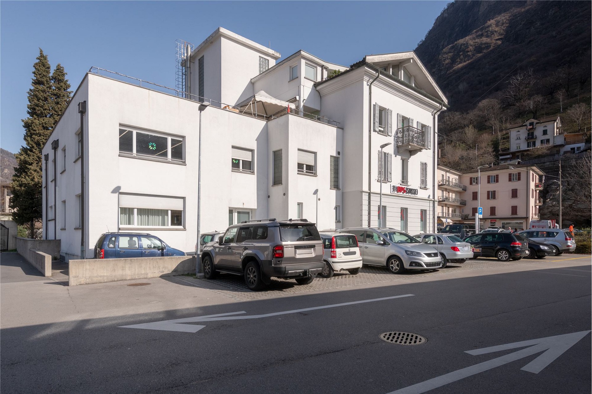 Weiße moderne Wohnanlage an einer Straße in Berglage
