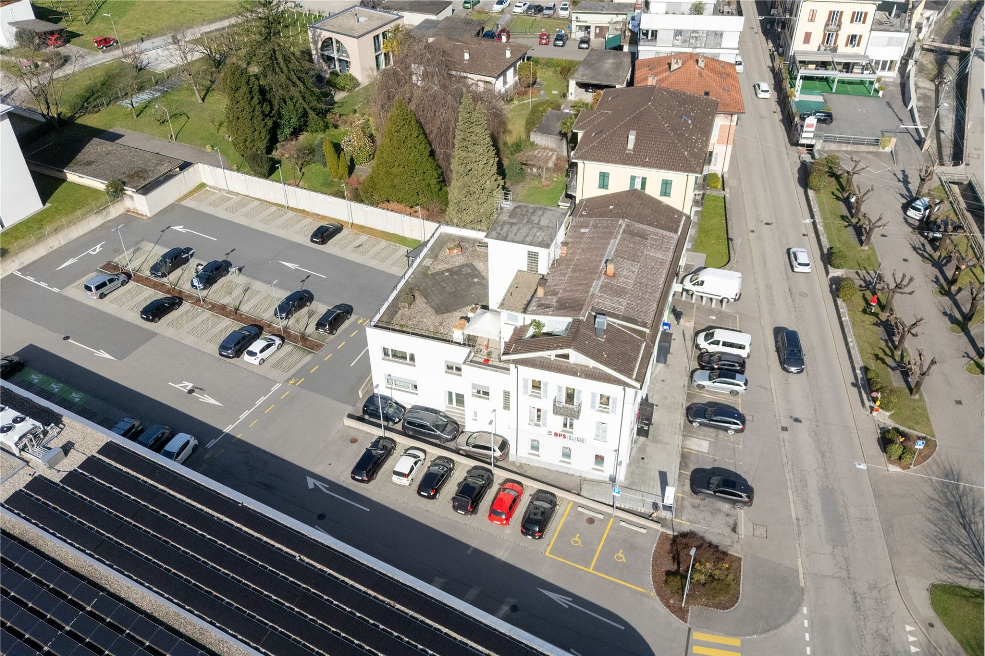 Luftaufnahme eines Wohn- und Geschäftsgebäudes mit Parkplatz