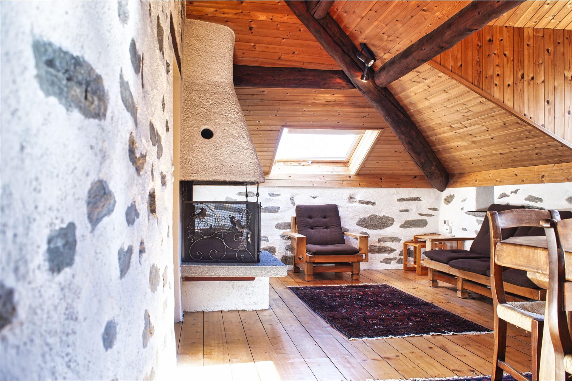 Gemütlicher Dachraum mit Kamin und rustikaler Holzausstattung
