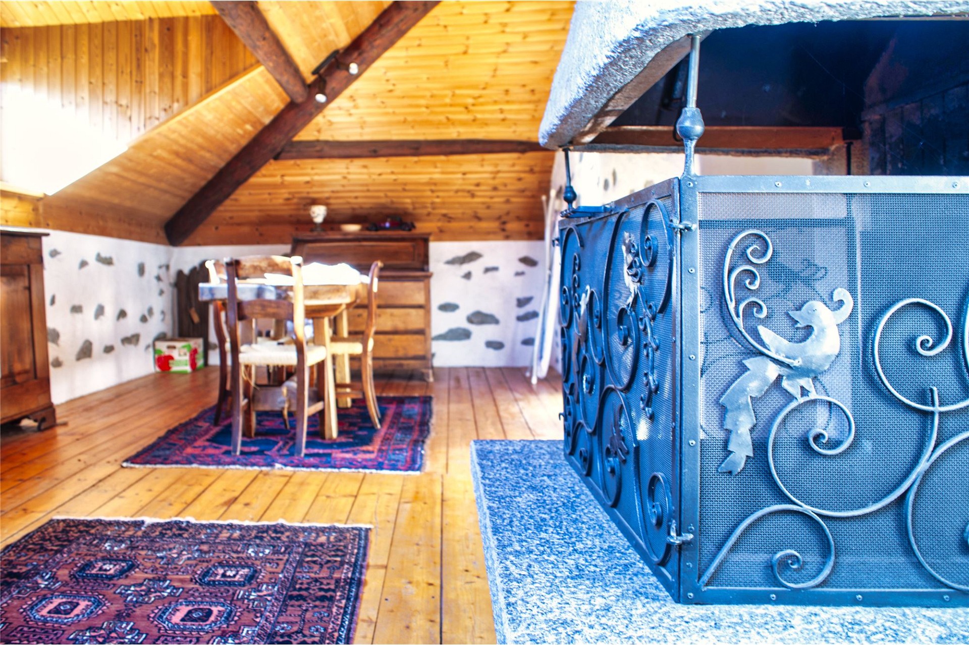 Gemütlicher Dachgeschossraum mit Holzdecke und Kamin