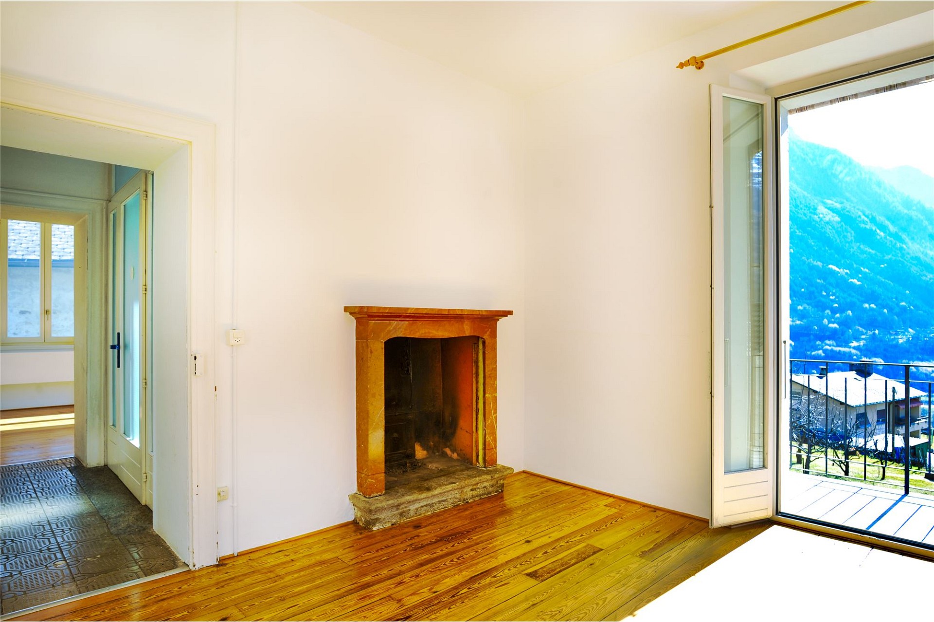 Wohnraum mit Kamin und Balkonblick
