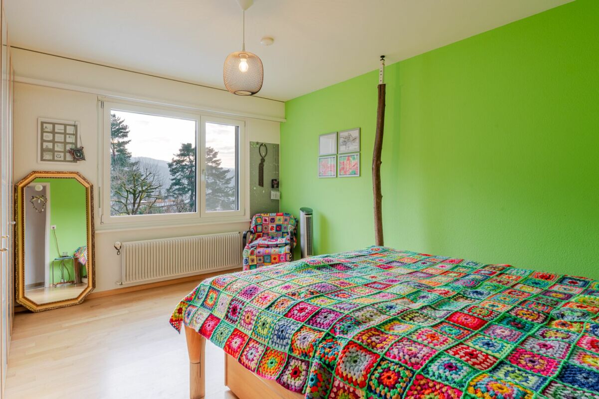 Buntes Schlafzimmer mit grüner Akzentwand