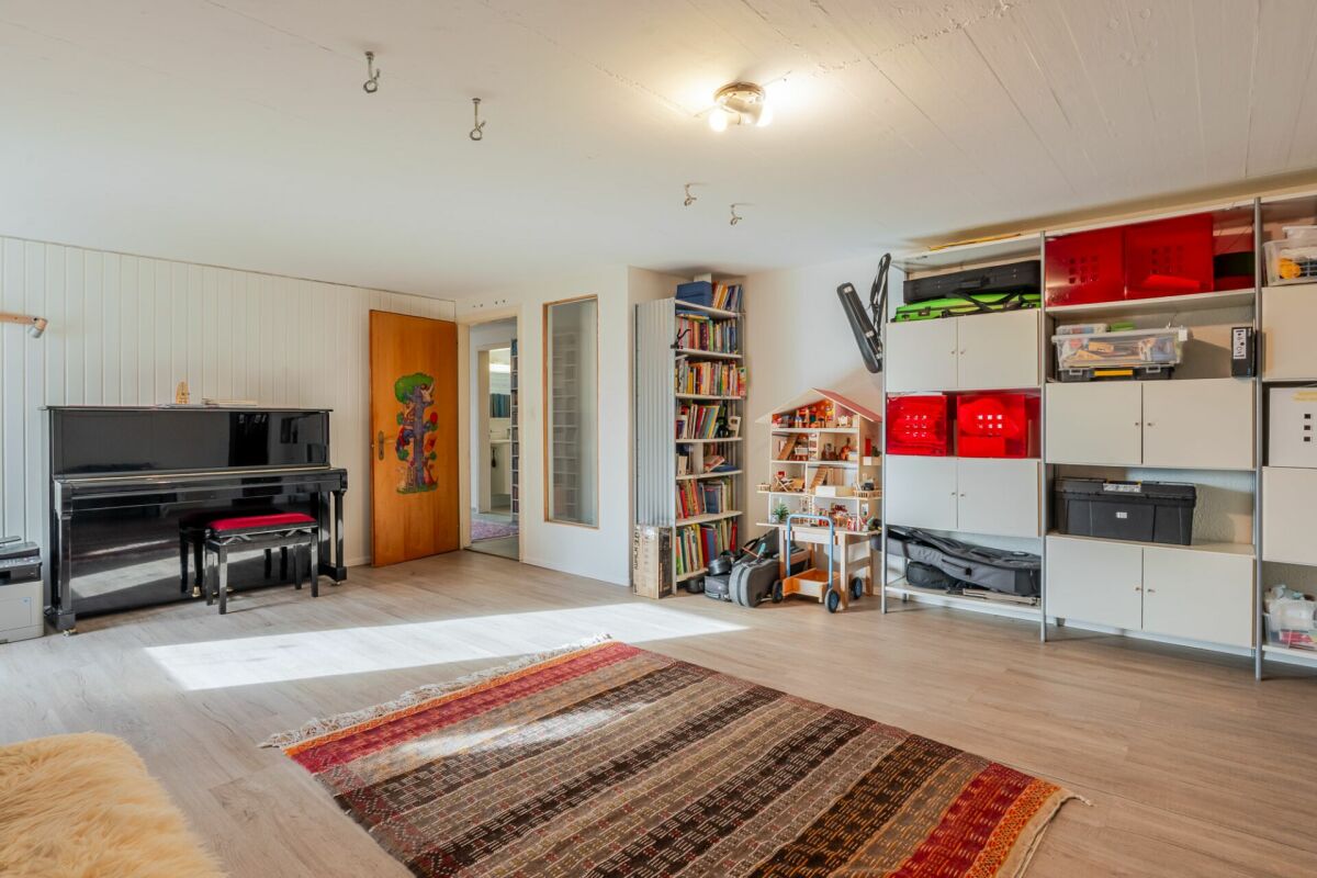Heller Wohnraum mit Klavier und Regalsystem