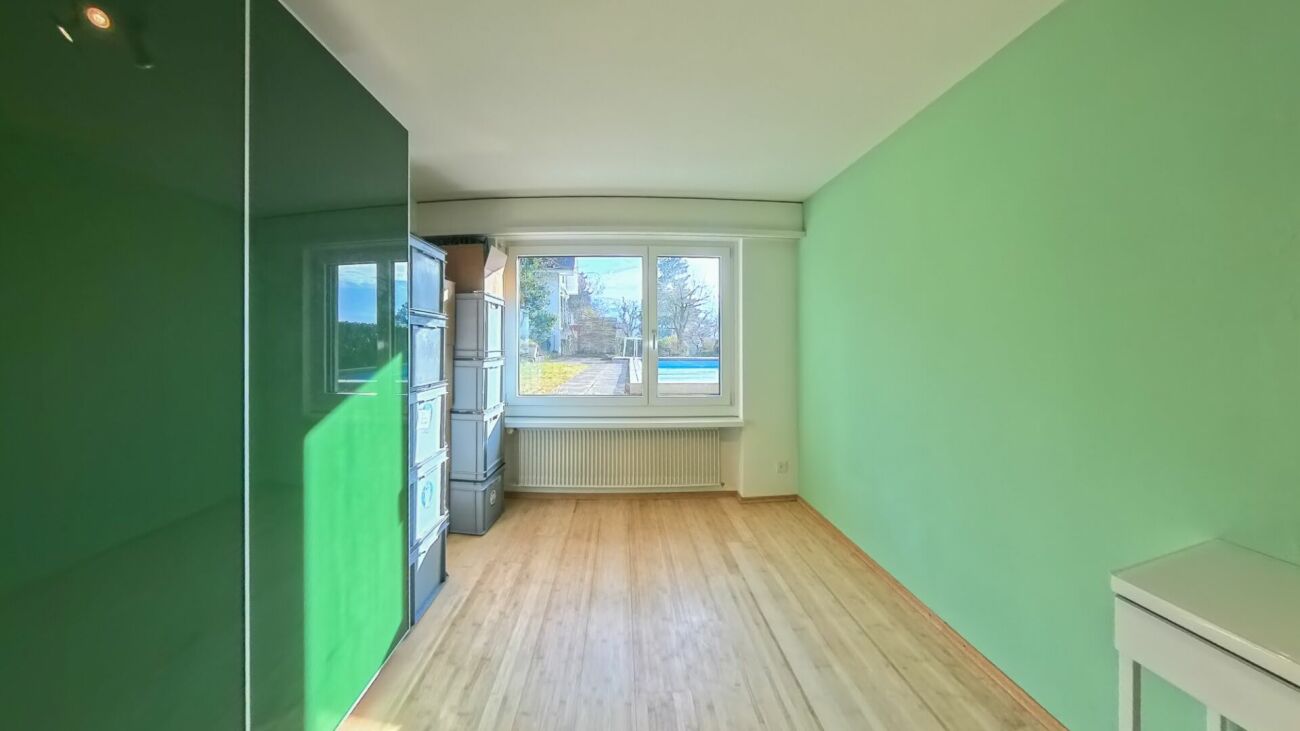 Heller Raum mit Fensterfront und mintgrünen Wänden