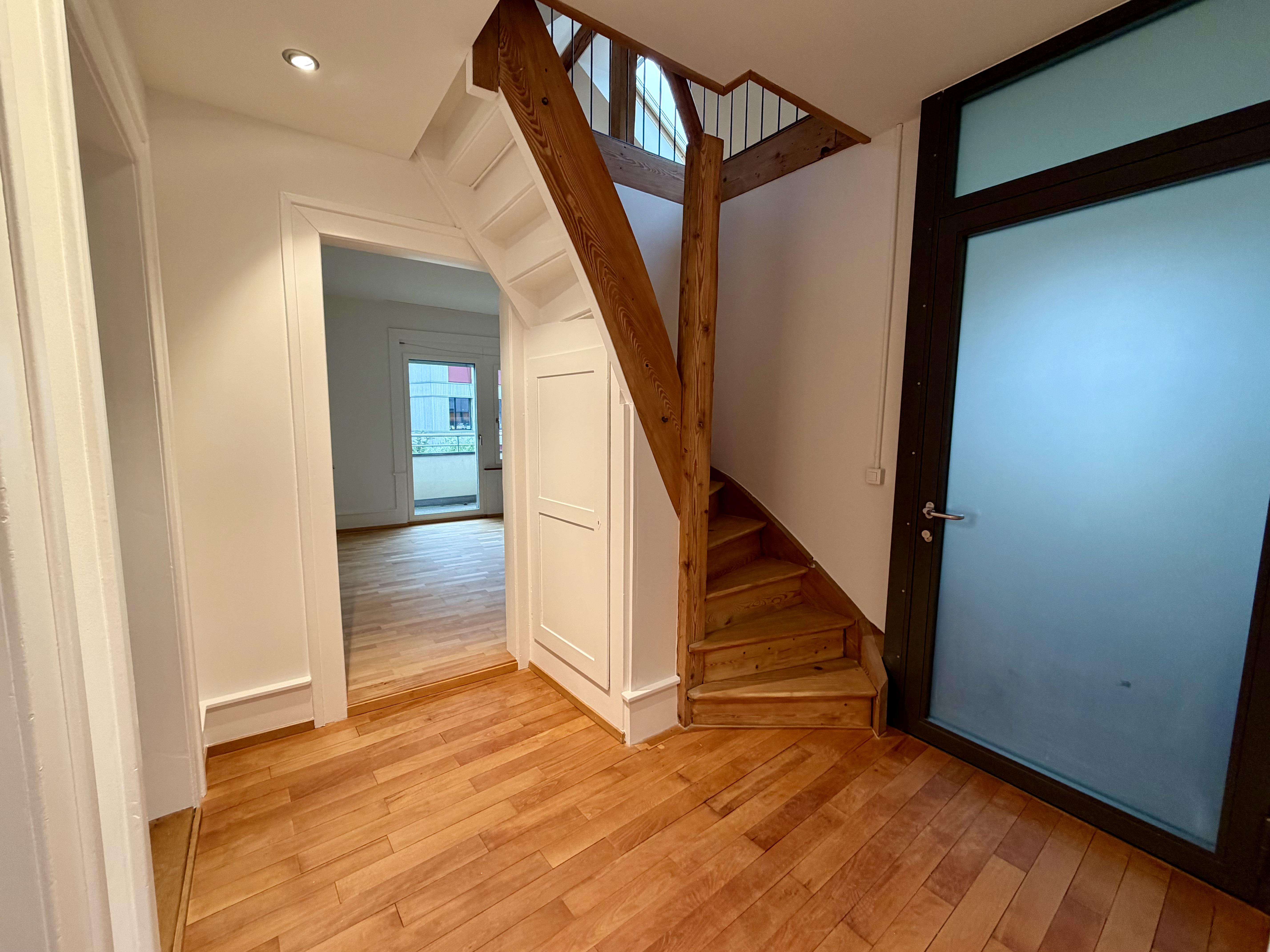 Flur mit Holztreppe und Glastür