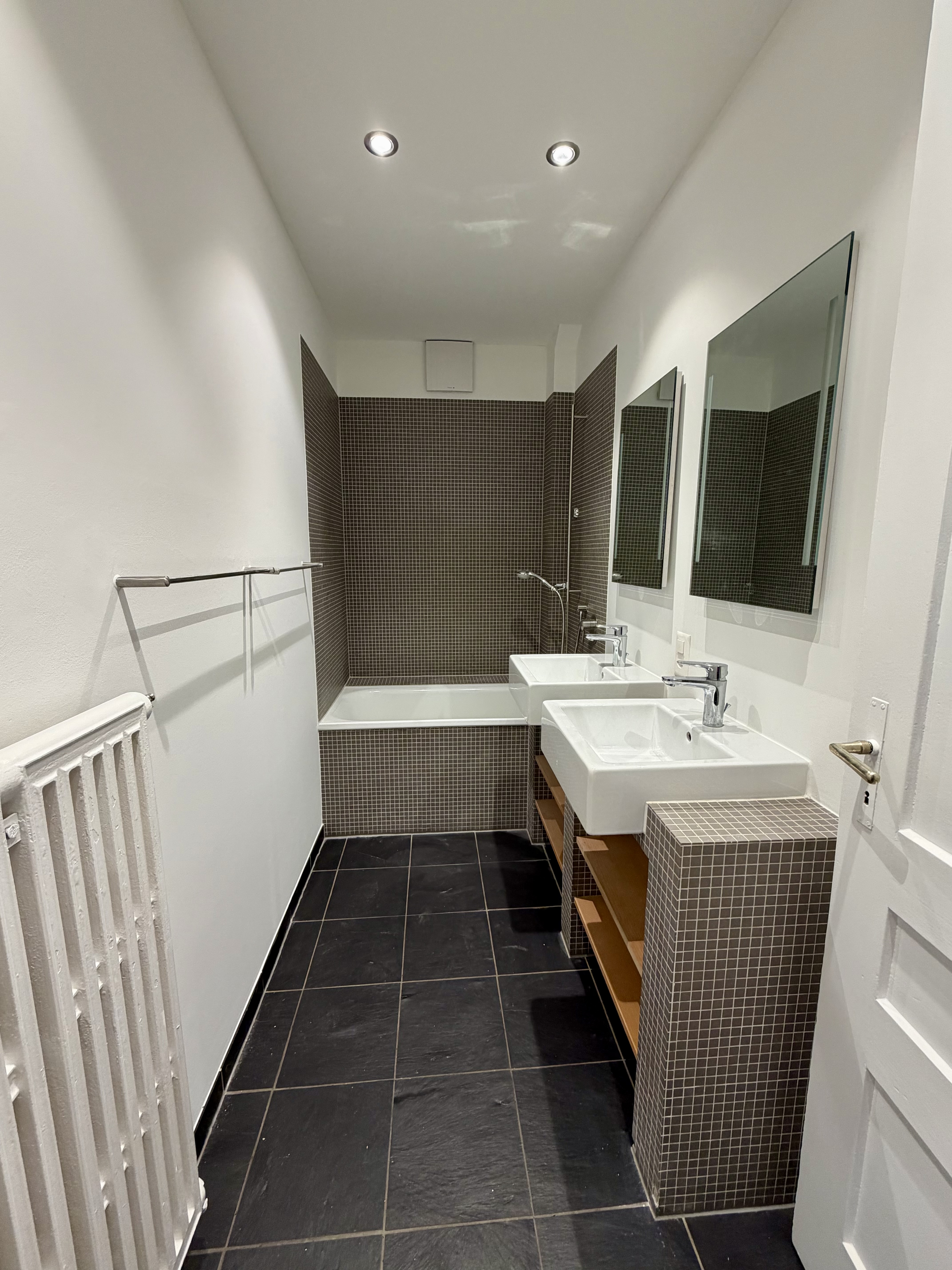 Schmales Badezimmer mit Badewanne und Doppelwaschtisch