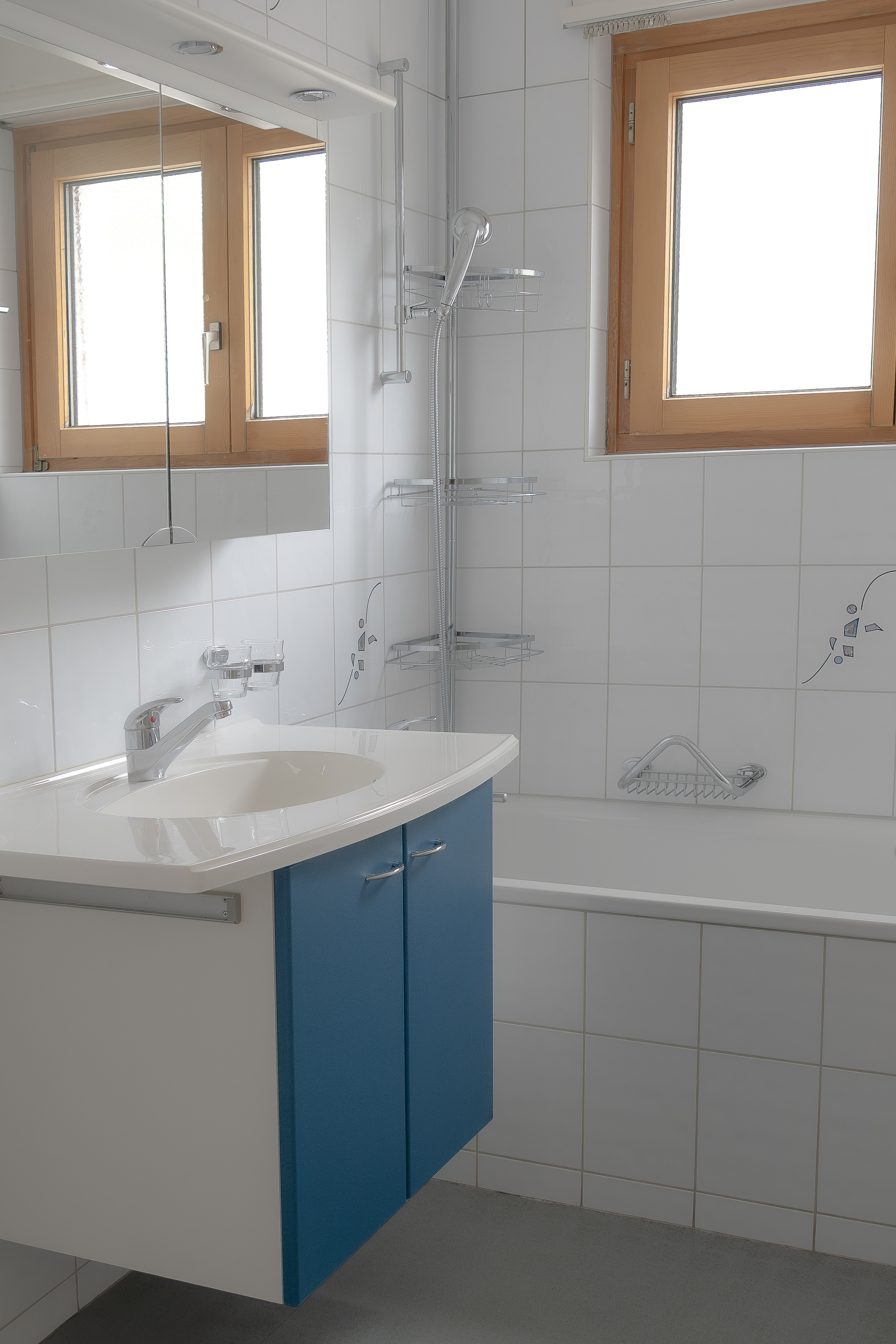 Modernes Badezimmer mit Badewanne und Holzfenstern