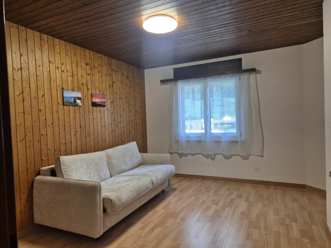 Gemütliches Zimmer mit Holzdecke und Sofa