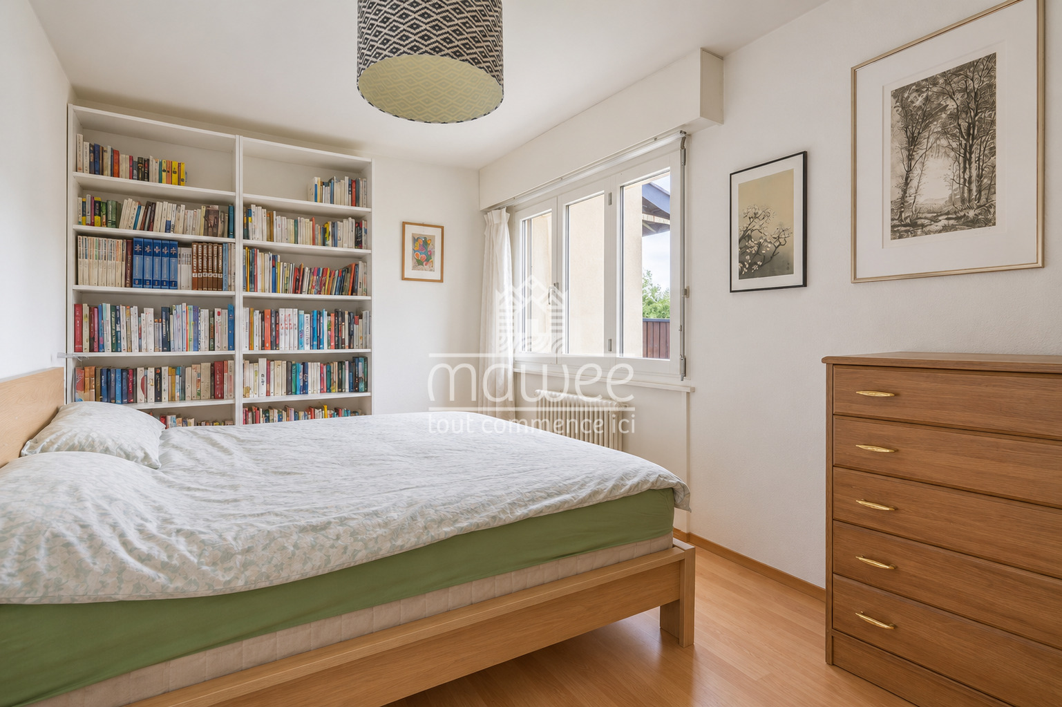 Helles Schlafzimmer mit Bücherregal und Holzkommode