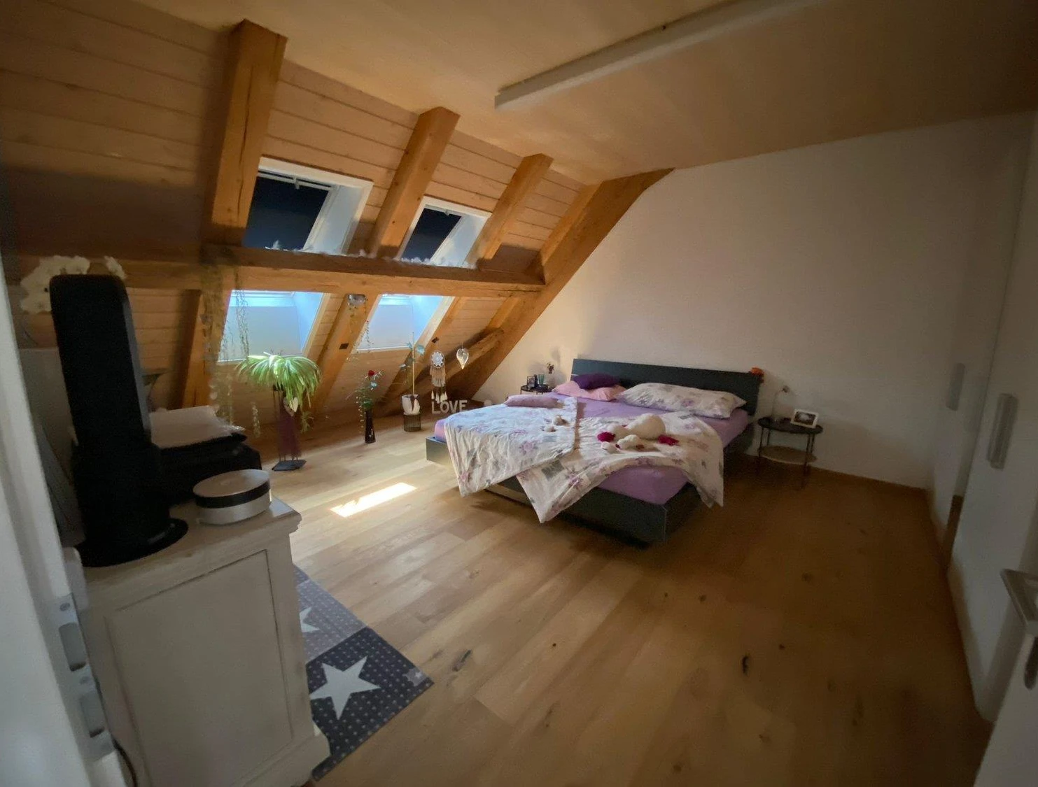 Dachgeschoss-Schlafzimmer mit sichtbaren Holzbalken