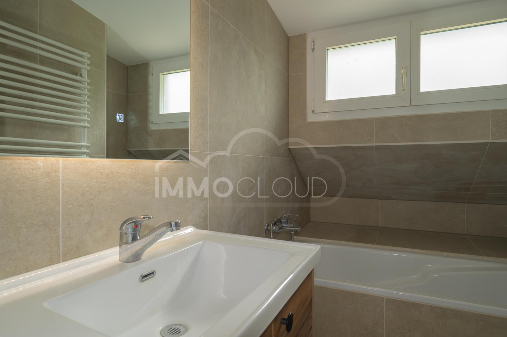 Helles Badezimmer mit Badewanne und Waschtisch