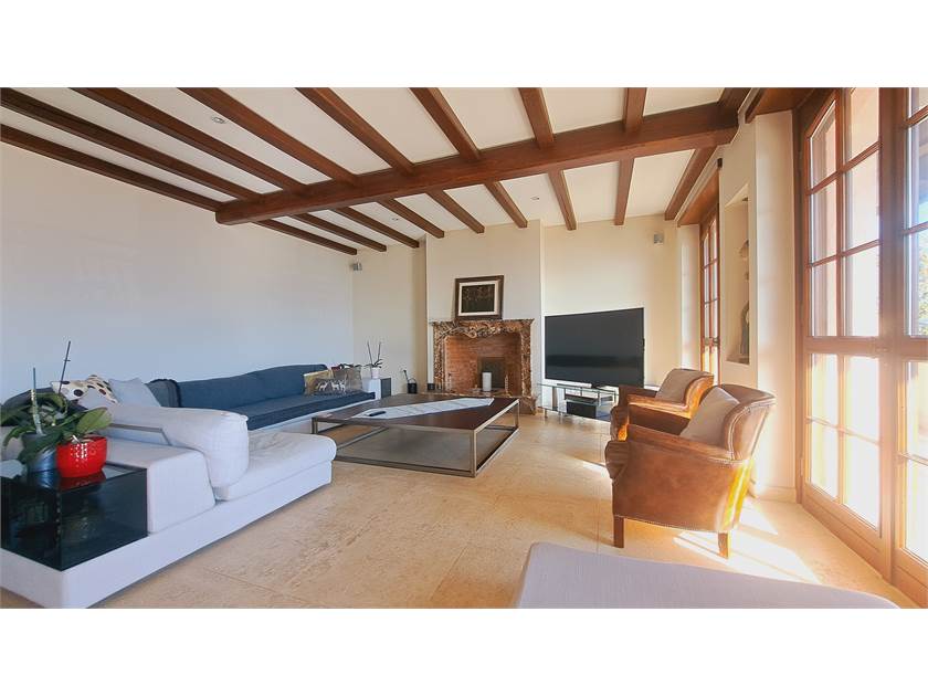Wohnzimmer mit sichtbaren Holzbalken und Kamin