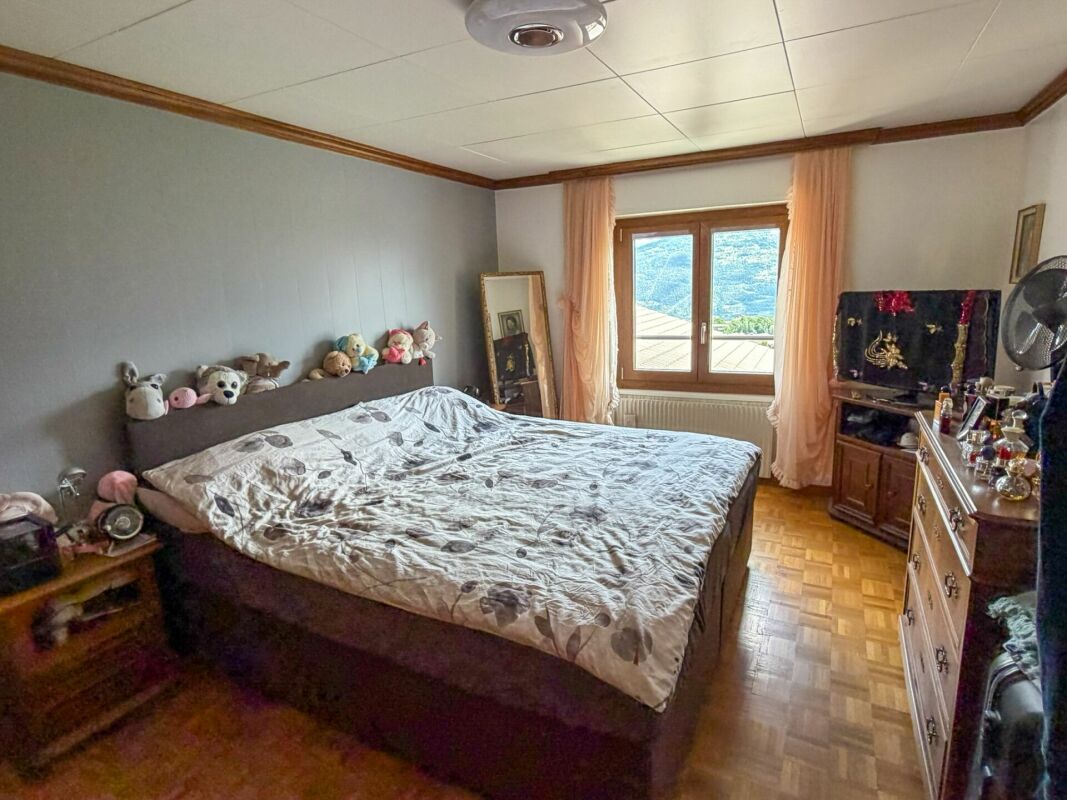 Schlafzimmer mit großem Fenster und Blick ins Grüne