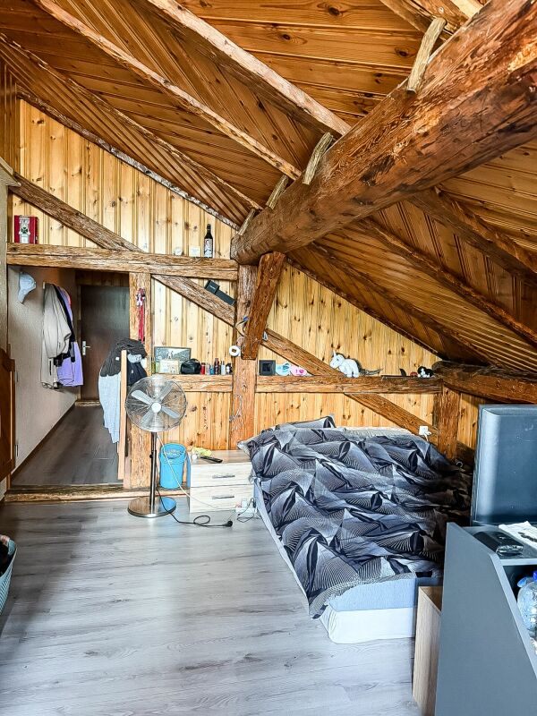 Dachzimmer mit sichtbaren Holzbalken
