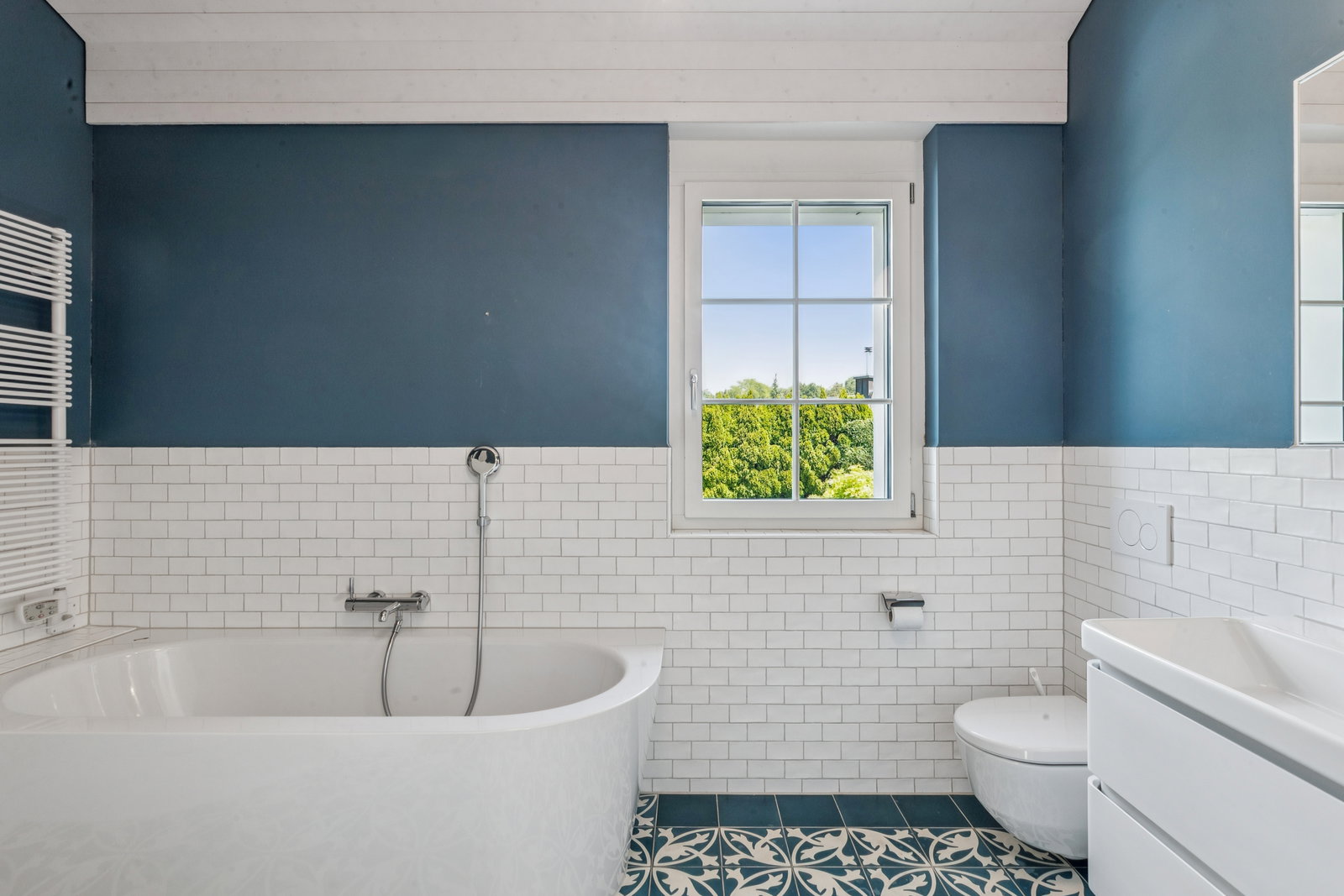 Modernes Badezimmer mit Badewanne und blau-weißer Gestaltung