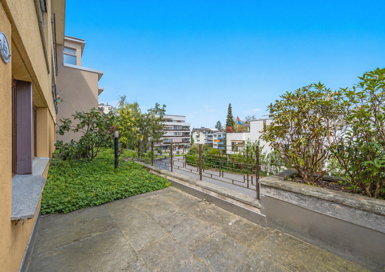 Außenbereich mit Terrasse und Gartenzaun