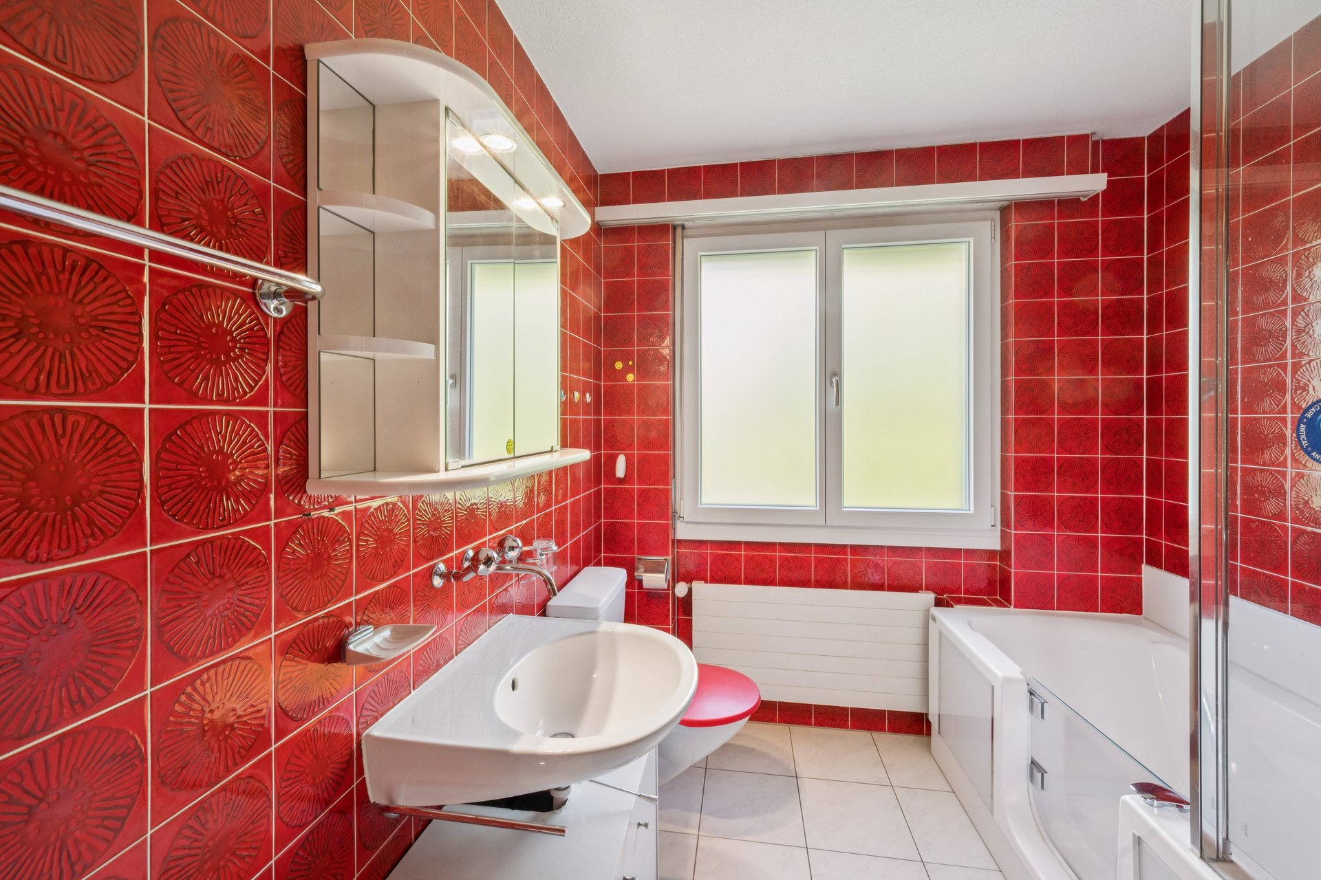 Bunt gefliestes Badezimmer mit Fenster