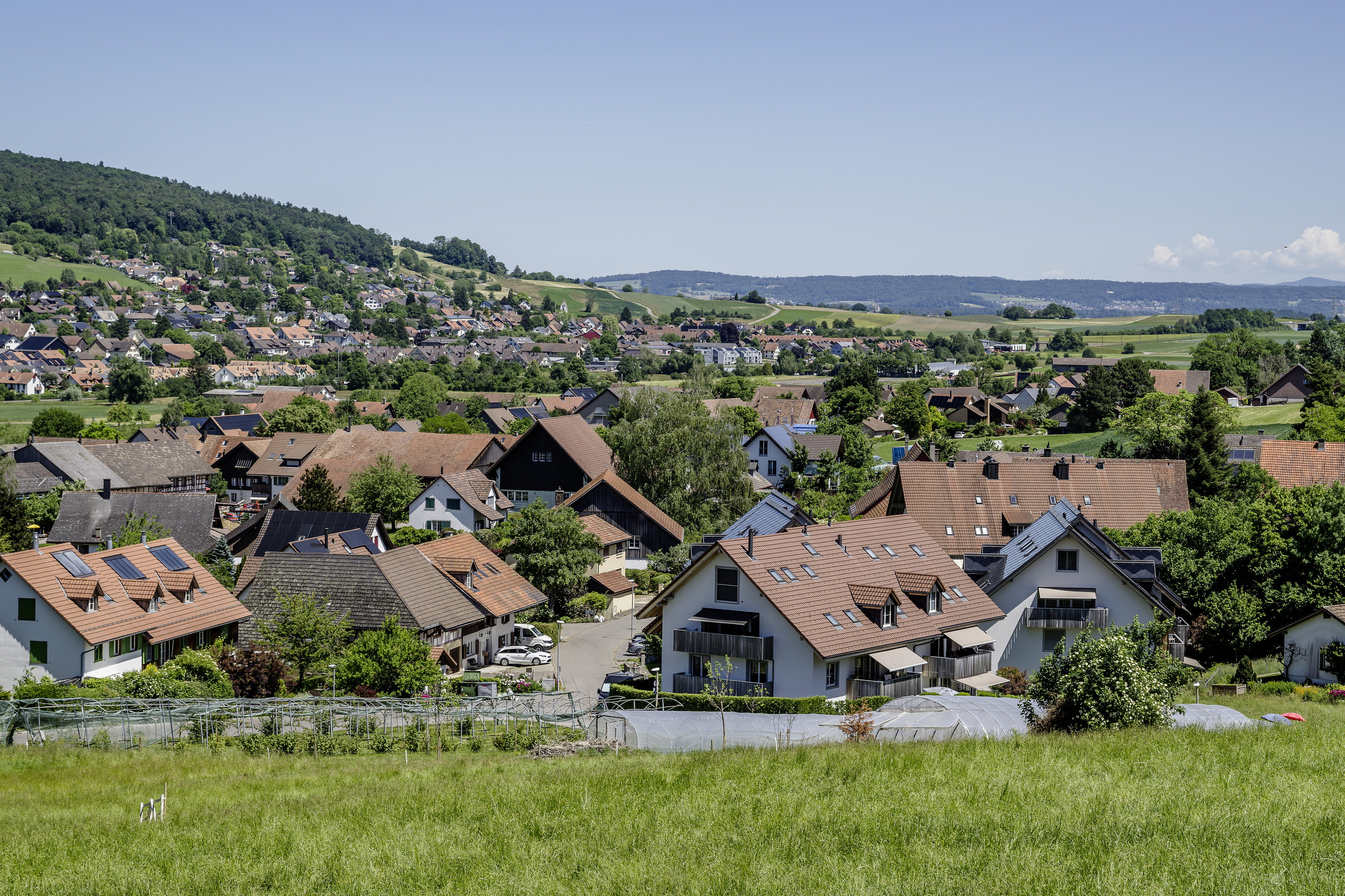 Ländliche Siedlung mit rotem Ziegeldach und Blick ins Tal