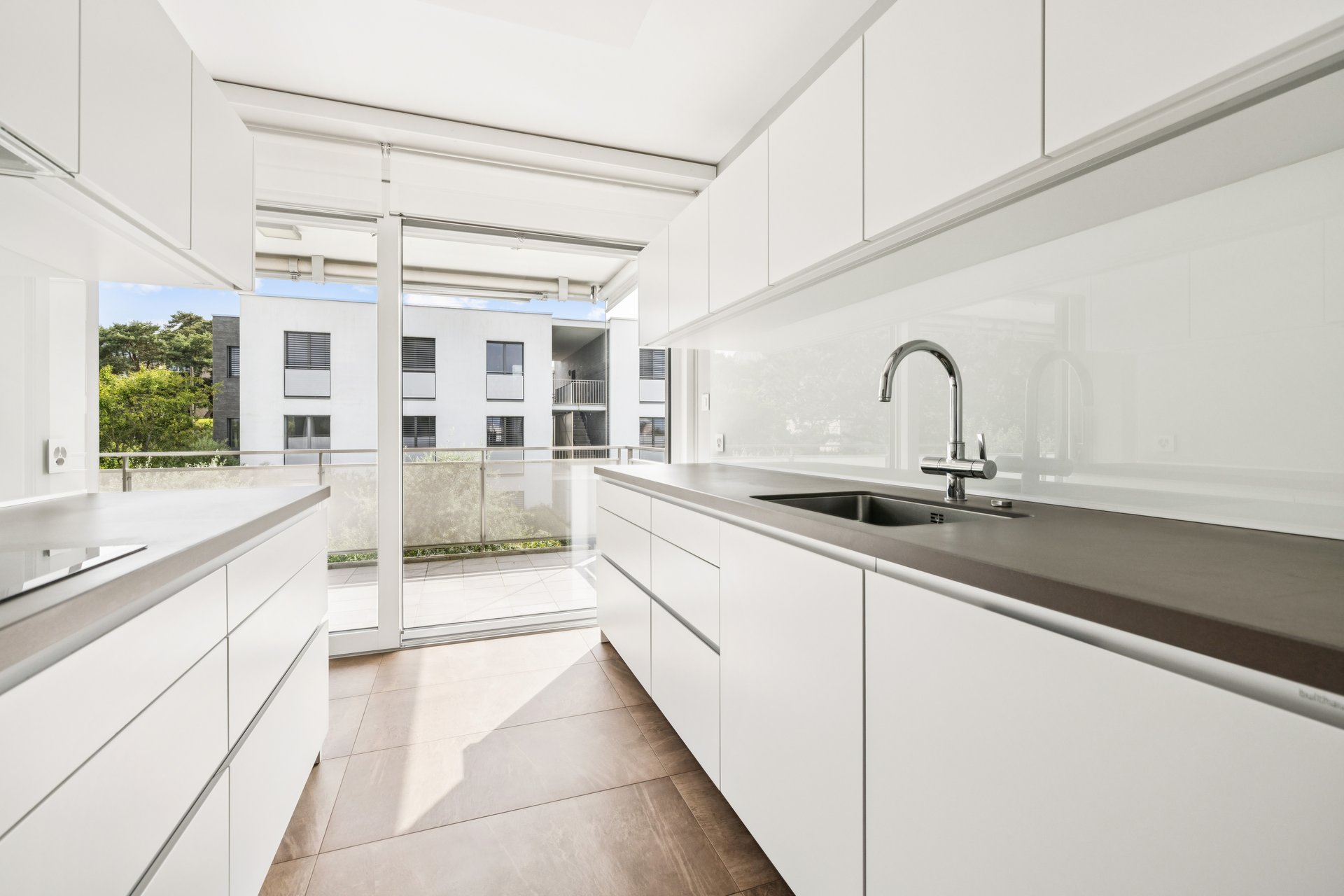 Moderne helle Küche mit Balkonblick