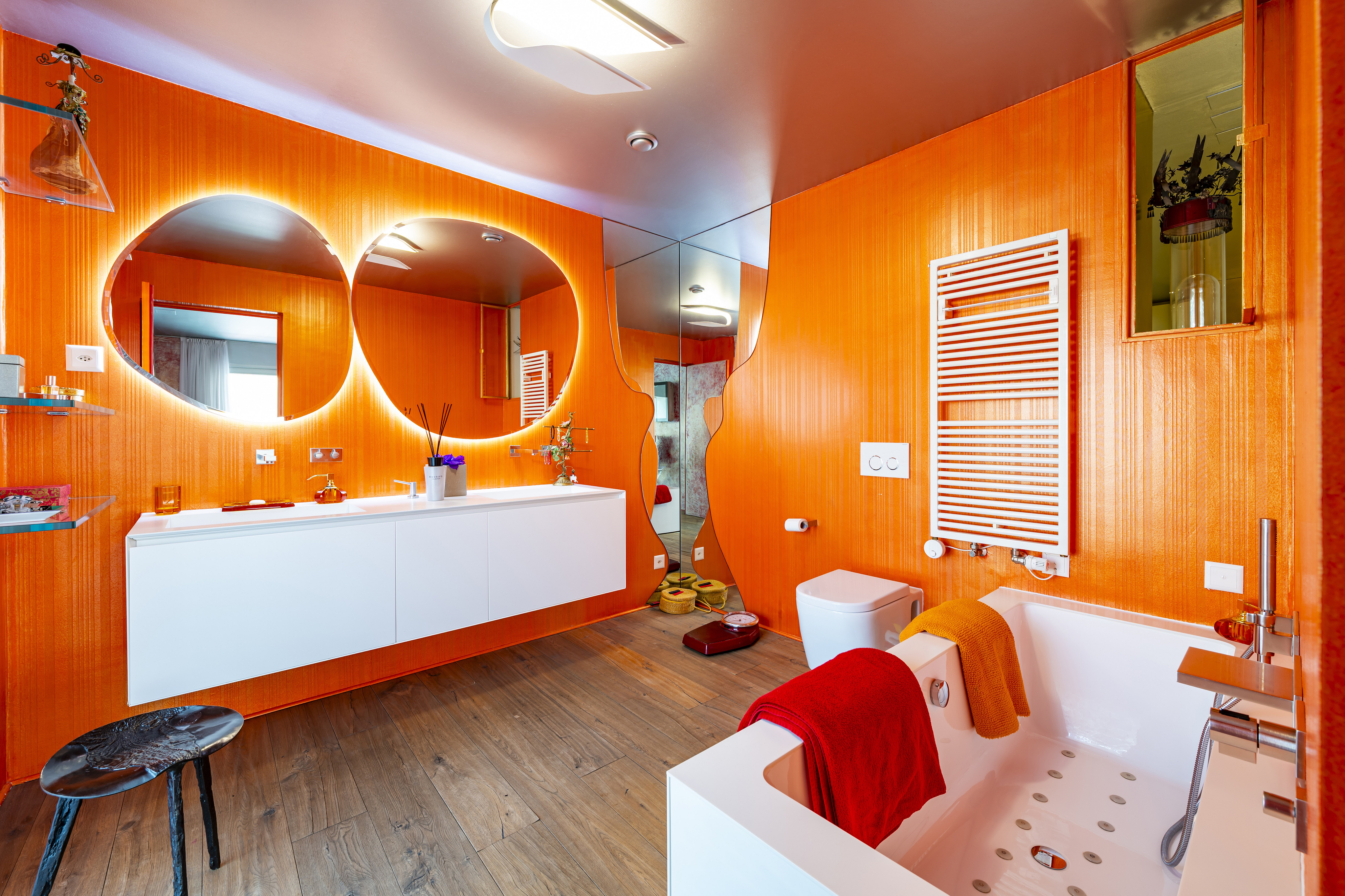Modernes Badezimmer mit auffälliger orangefarbener Wandgestaltung