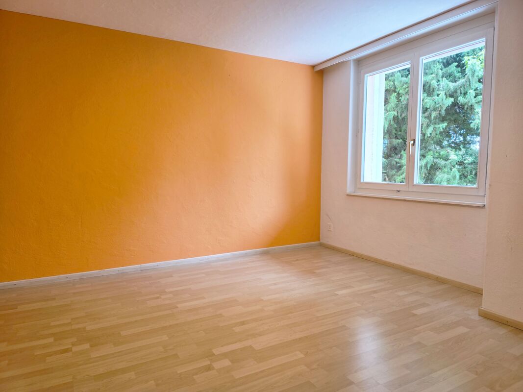 Leerer, heller Raum mit orangefarbener Akzentwand