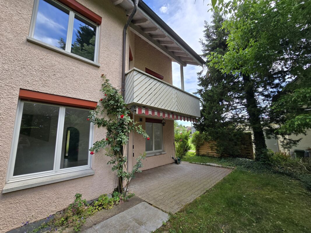 Hausfassade mit Balkon und Garten