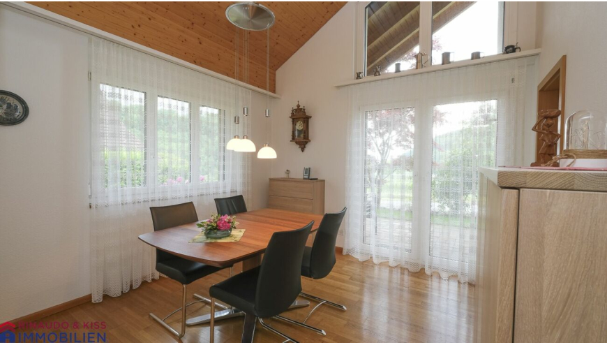 Essbereich mit hoher Decke und großen Fensterfronten