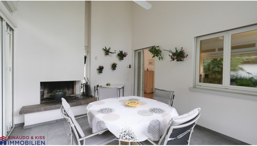 Überdachte Terrasse mit Essbereich und Kamin