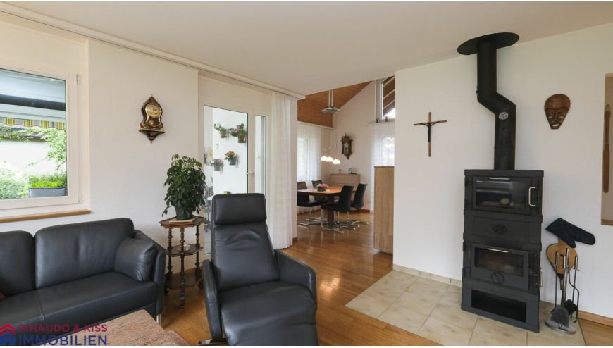 Wohnzimmer mit Kamin und Essbereich im Hintergrund