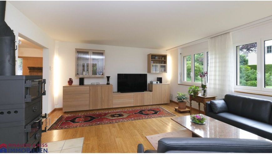 Helles Wohnzimmer mit TV-Wand und Kaminofen
