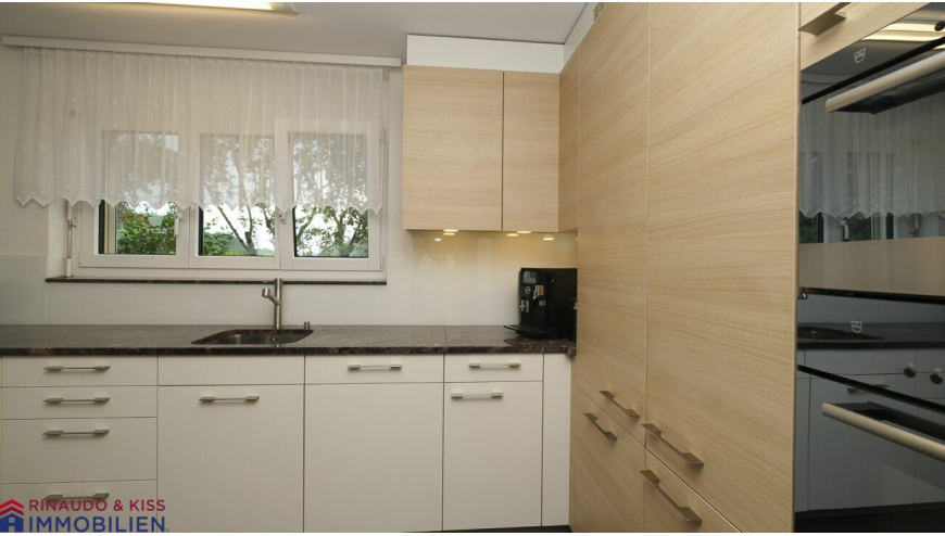 Helle Küche mit Fensterfront und Holzschrankwand